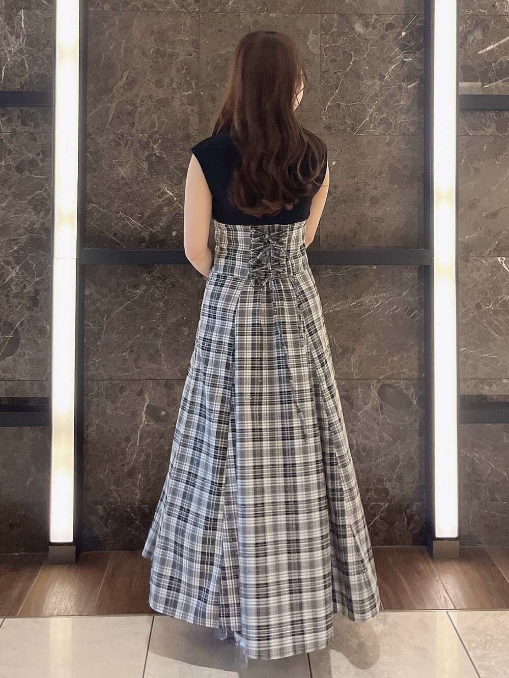 グレー系のニット/セーター、ブラック系のワンピース、ブラック系のパンプスを着用したレディースの夏コーディネートの9枚目の写真