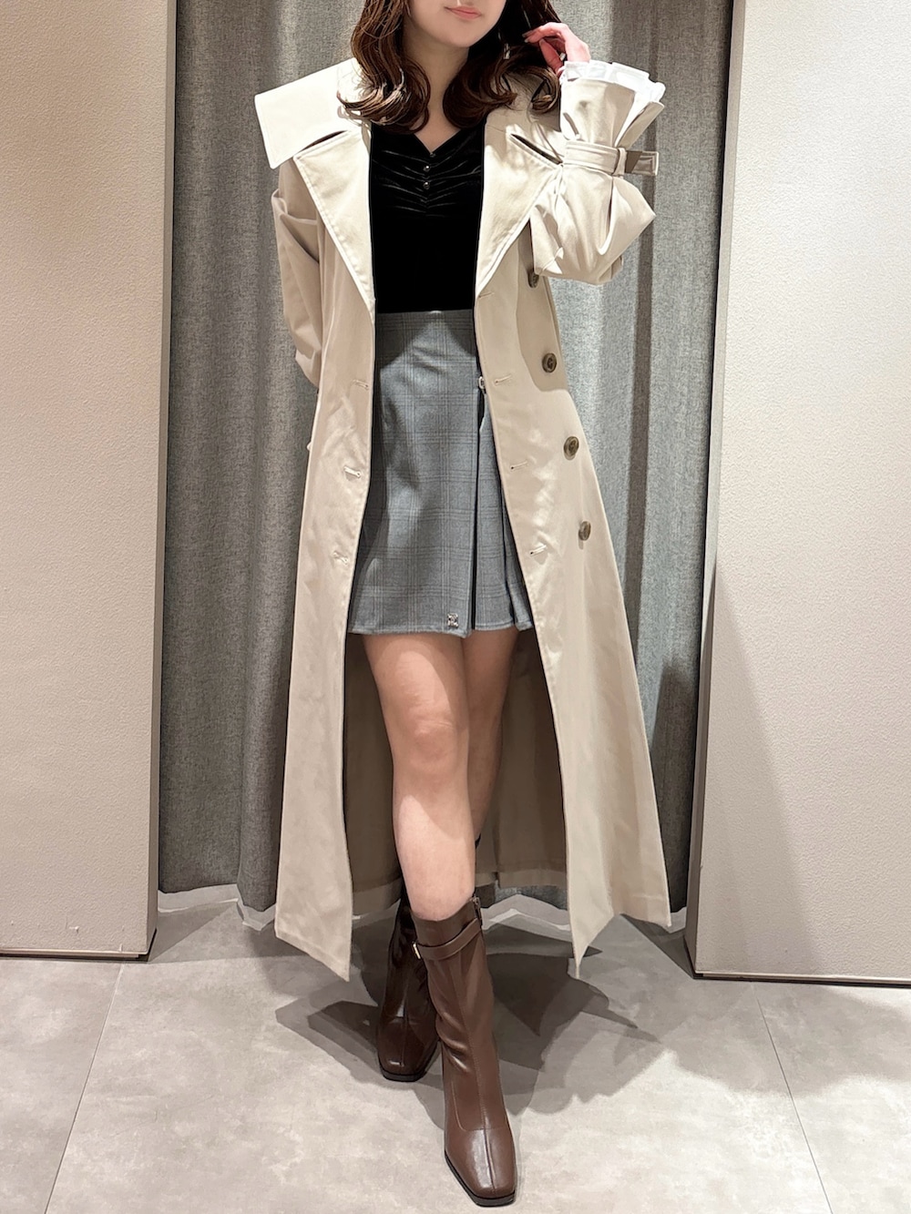 ブラック系のTシャツ/カットソー、ベージュ系のトレンチコート、グレー系のスカートを着用したレディースの春コーディネートの3枚目の写真