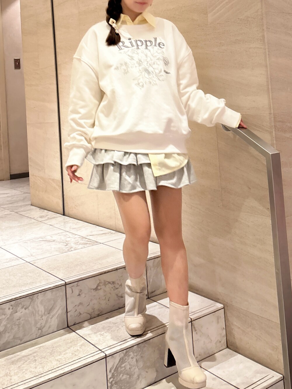 ホワイト系のスウェット、イエロー系のシャツ/ブラウス、グレー系のスカートを着用したレディースの春コーディネートの2枚目の写真