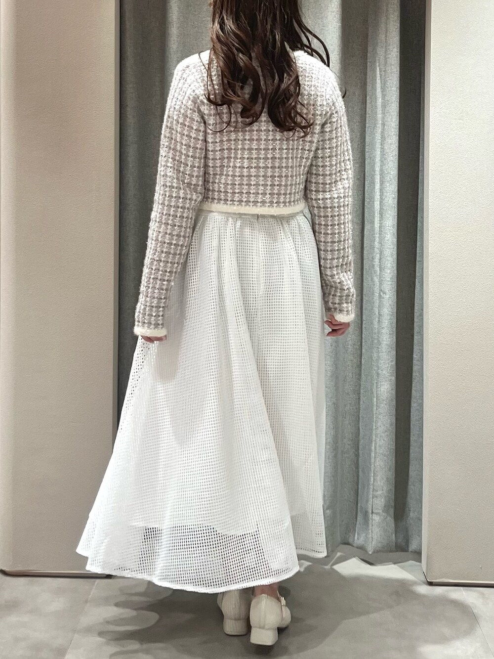 パープル系のノーカラージャケット、ホワイト系のワンピース、ホワイト系のパンプスを着用したレディースの春コーディネートの9枚目の写真