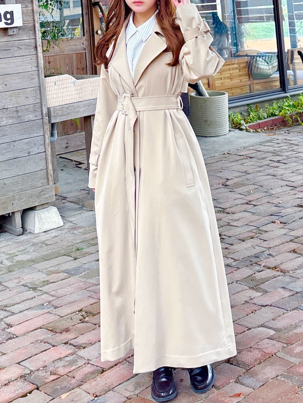 ベージュ系のトレンチコートを着用したレディースの春コーディネートの5枚目の写真