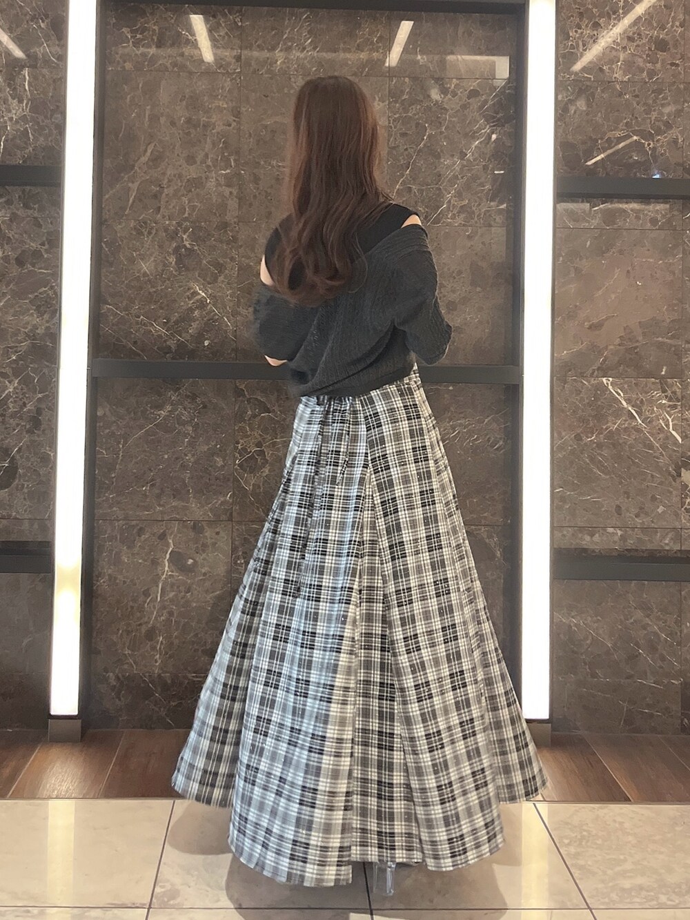 グレー系のニット/セーター、ブラック系のワンピース、ブラック系のパンプスを着用したレディースの夏コーディネートの3枚目の写真