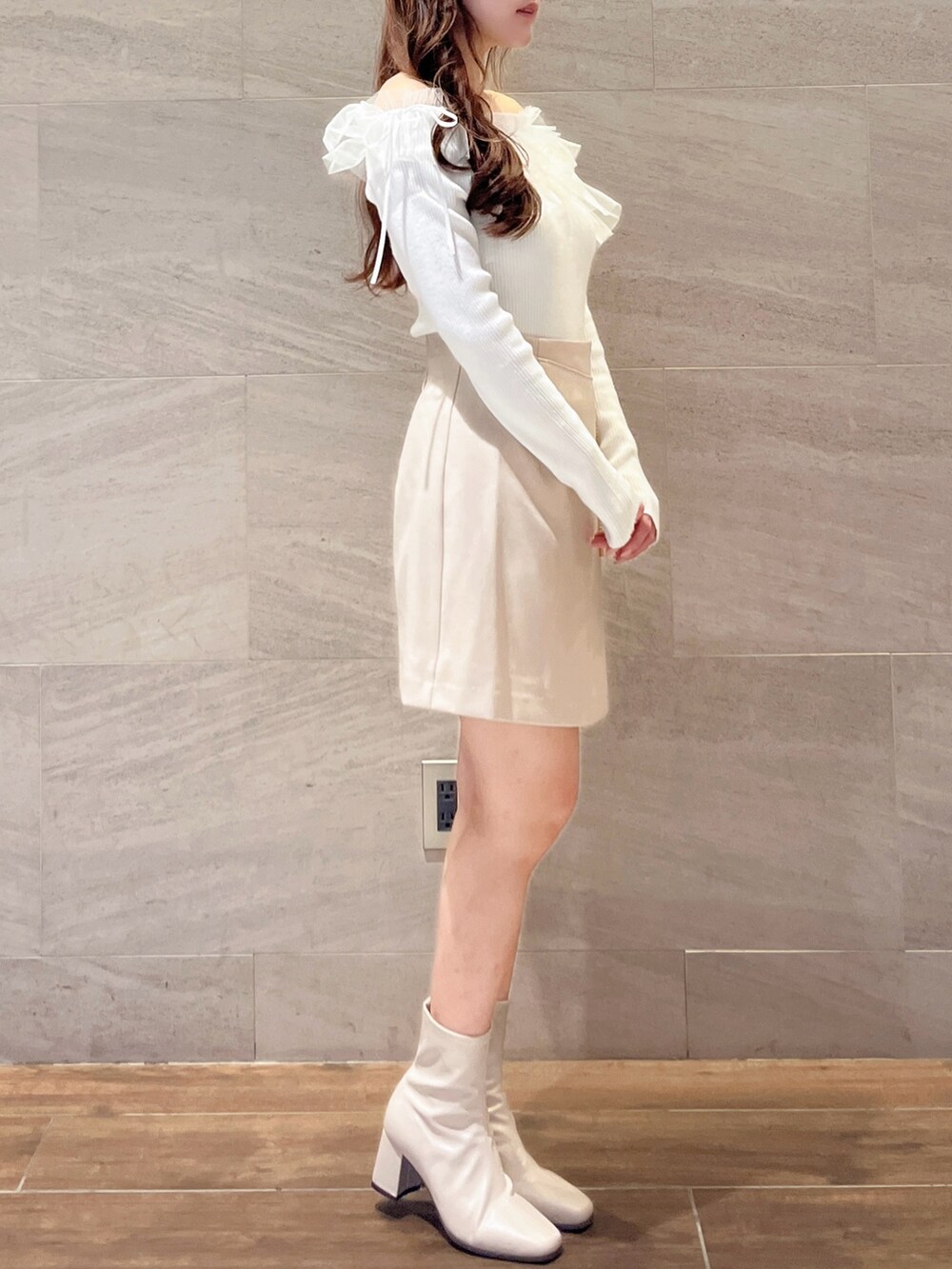 ホワイト系のニット/セーター、ベージュ系のスカート、ベージュ系のブーツを着用したレディースの秋コーディネートの5枚目の写真