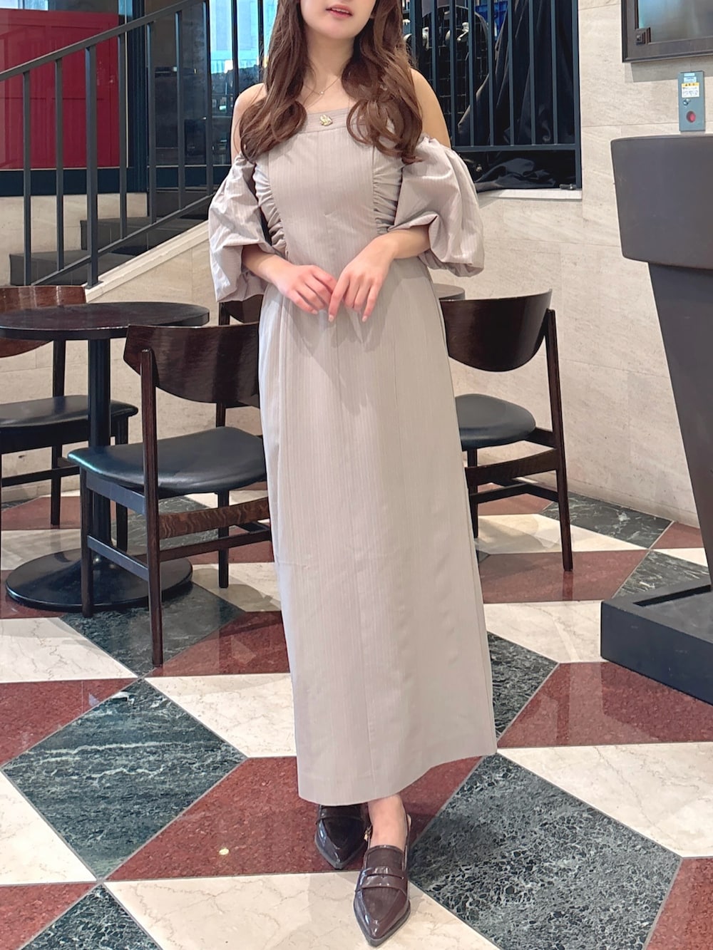 グレー系のワンピース、ブラウン系のローファーを着用したレディースの春コーディネートの2枚目の写真