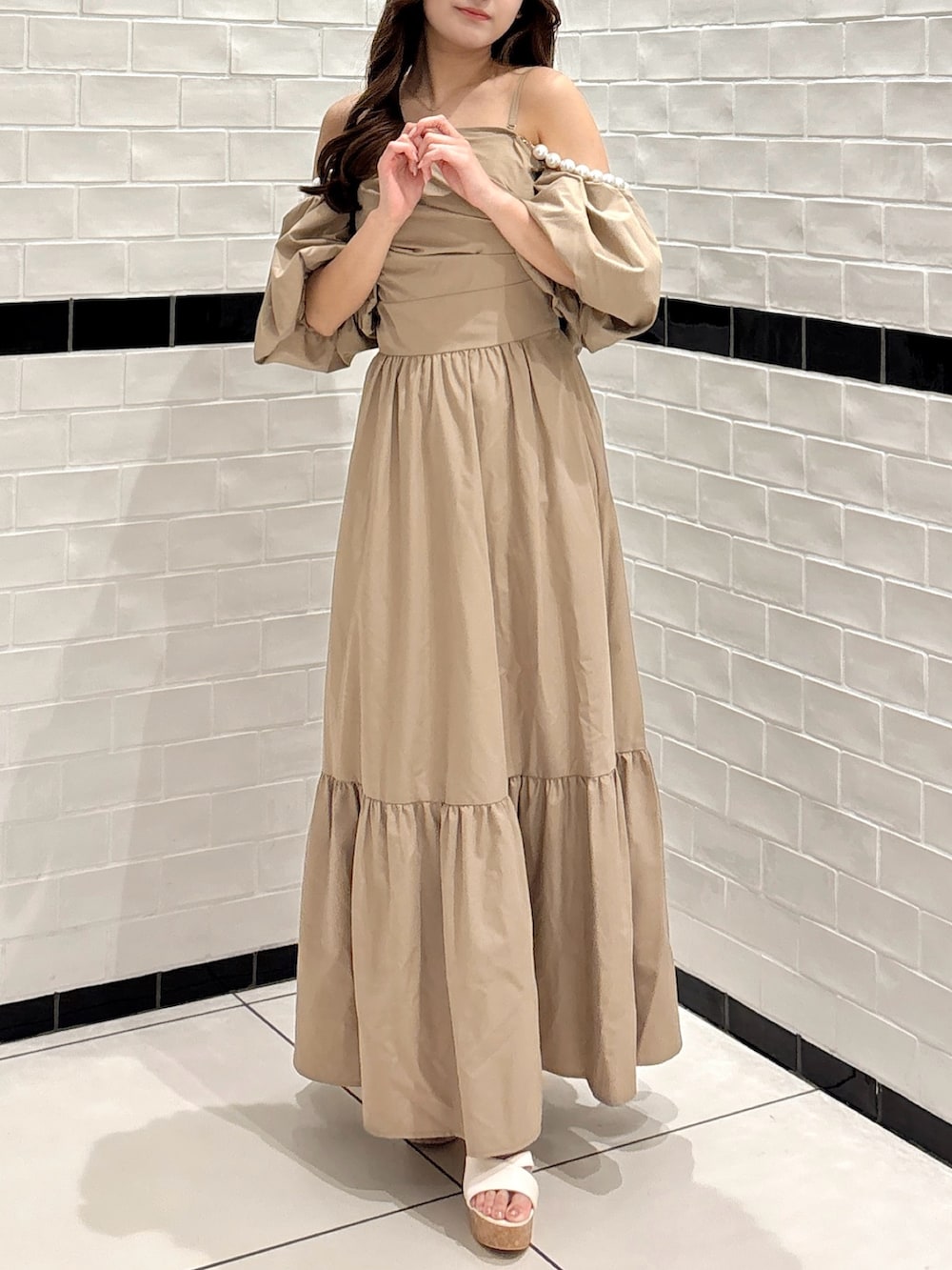 ベージュ系のワンピース、ホワイト系のサンダルを着用したレディースの夏コーディネートの3枚目の写真