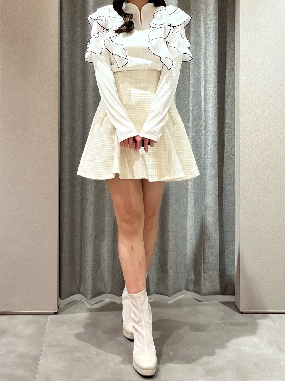 ホワイト系のTシャツ/カットソー、ホワイト系のスカート、ホワイト系のブーツを着用したレディースの春コーディネートの4枚目の写真