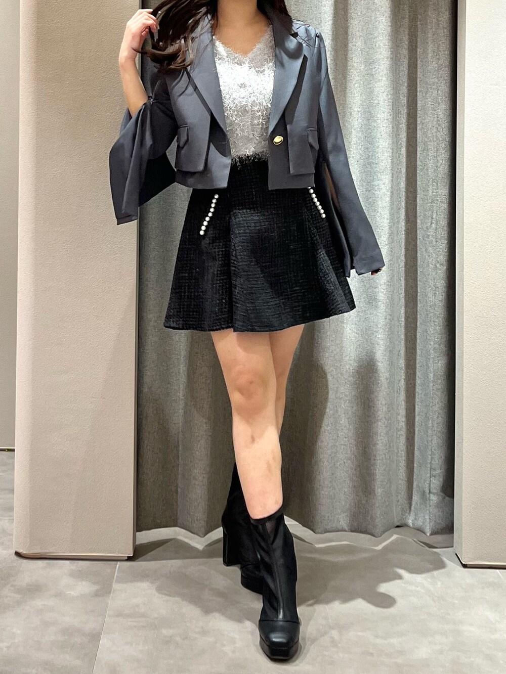 グレー系のテーラードジャケット、グレー系のニット/セーター、ブラック系のスカートを着用したレディースの春コーディネートの5枚目の写真