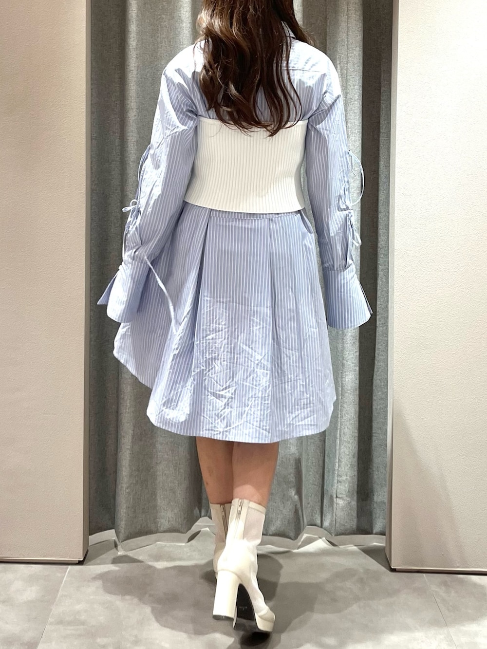 ホワイト系のキャミソール、ブルー系のシャツワンピース、ホワイト系のブーツを着用したレディースの冬コーディネートの9枚目の写真