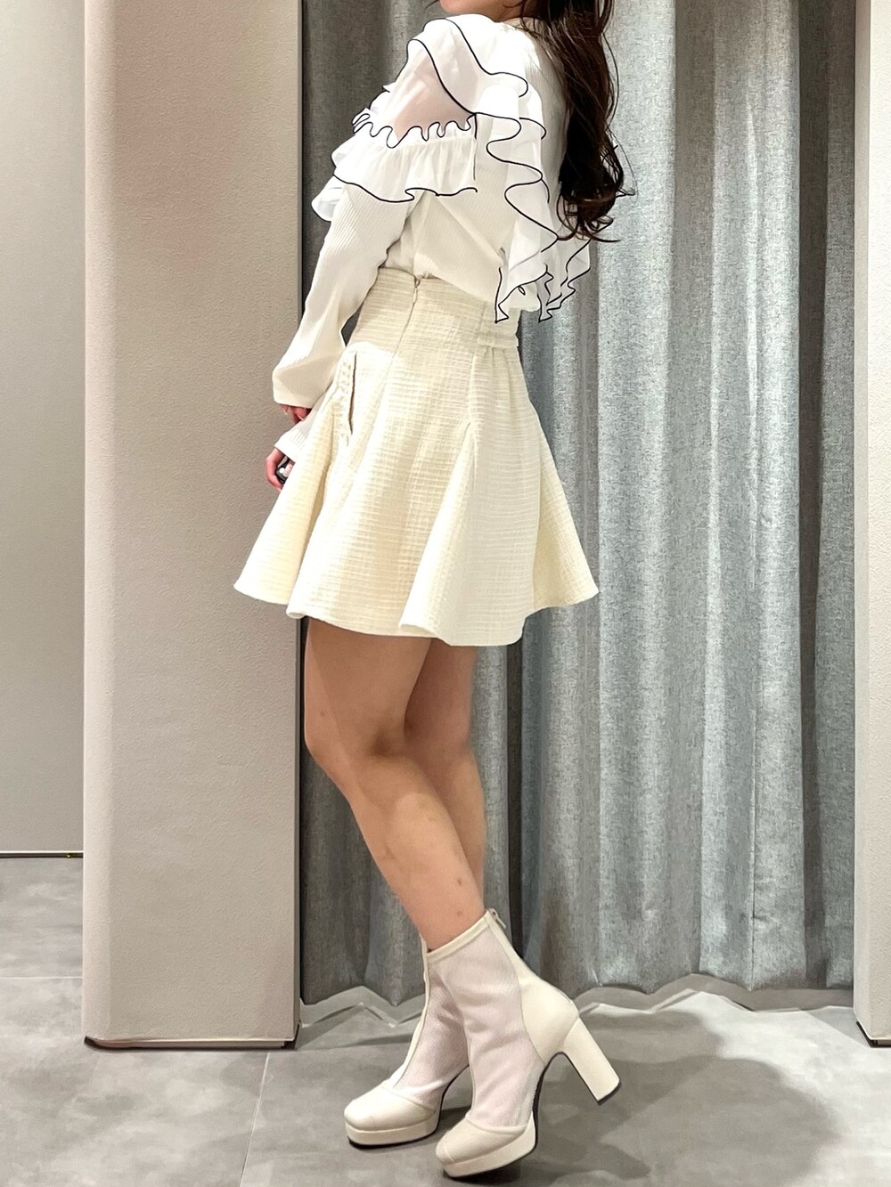 ホワイト系のTシャツ/カットソー、ホワイト系のスカート、ホワイト系のブーツを着用したレディースの春コーディネートの8枚目の写真