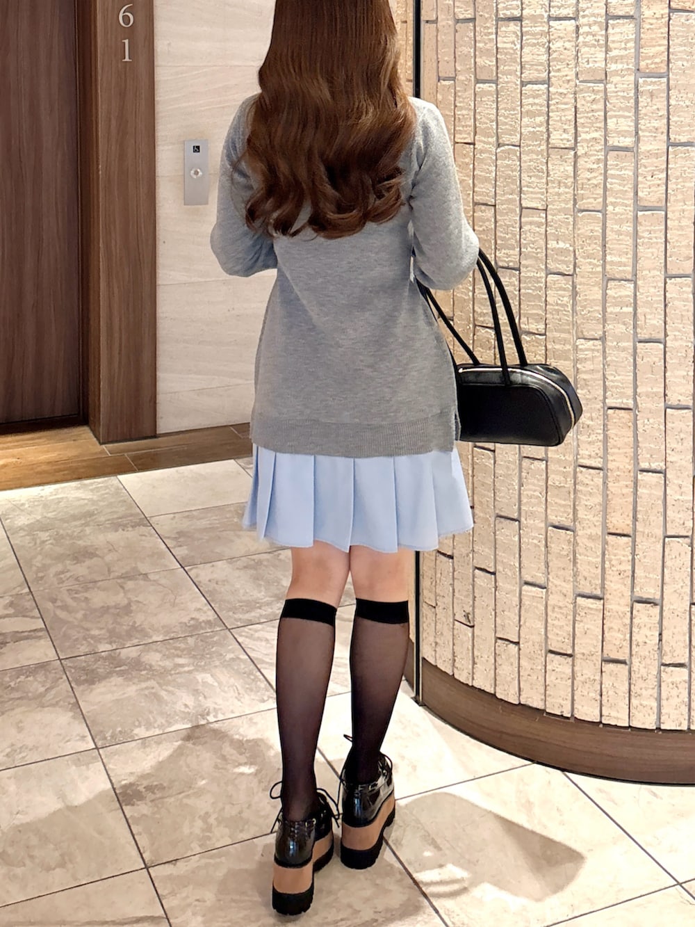 その他のローファー、グレー系のワンピース、ブラック系のハンドバッグを着用したレディースの秋コーディネートの6枚目の写真