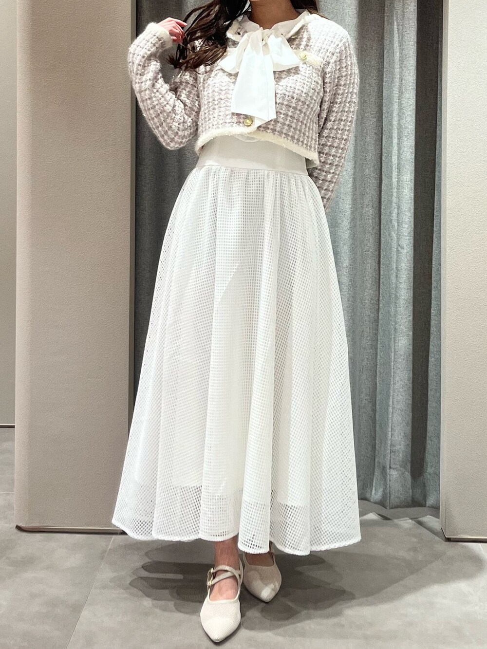 パープル系のノーカラージャケット、ホワイト系のワンピース、ホワイト系のパンプスを着用したレディースの春コーディネートの3枚目の写真