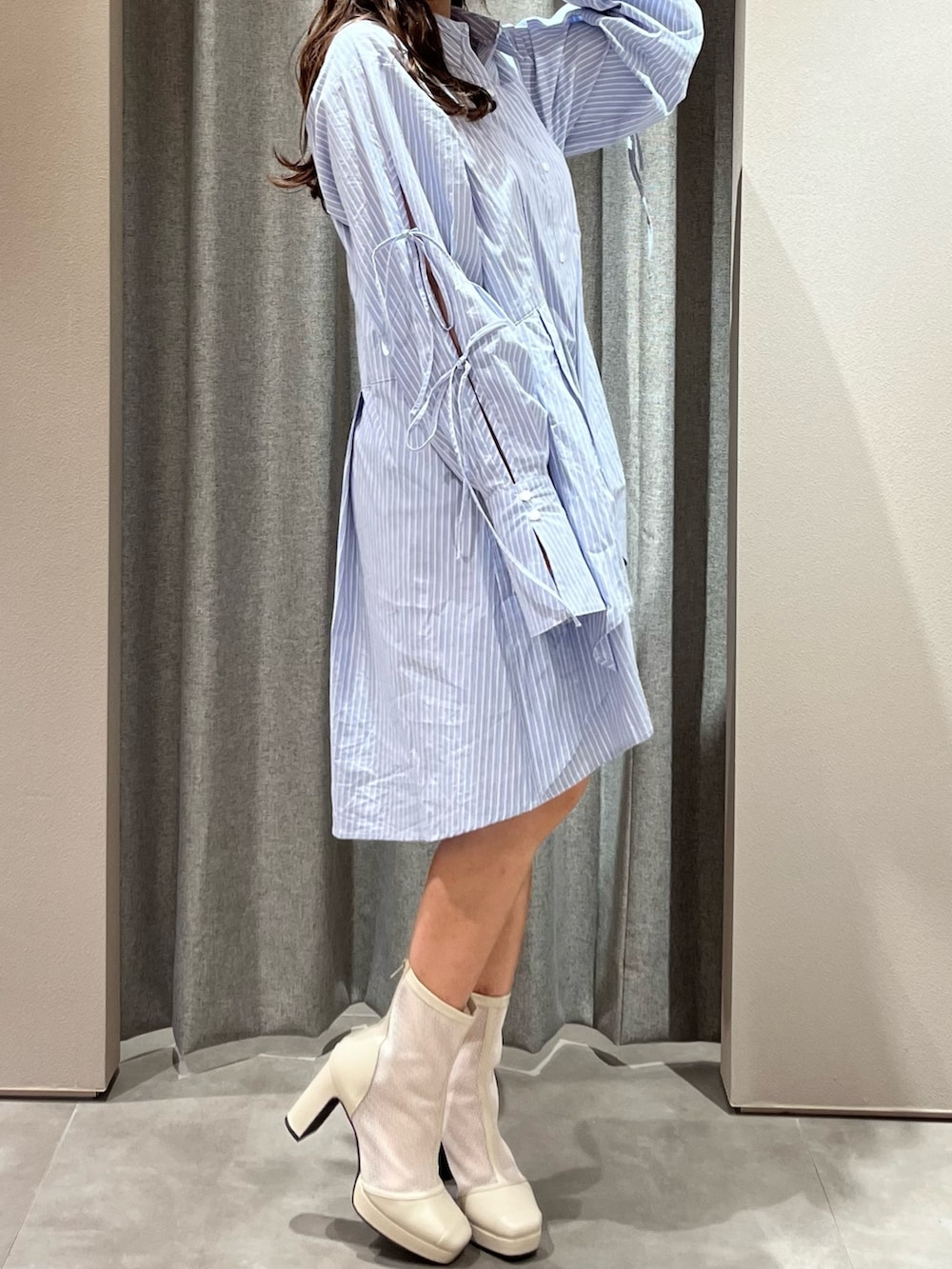 ブルー系のシャツワンピース、ホワイト系のブーツを着用したレディースの冬コーディネートの5枚目の写真