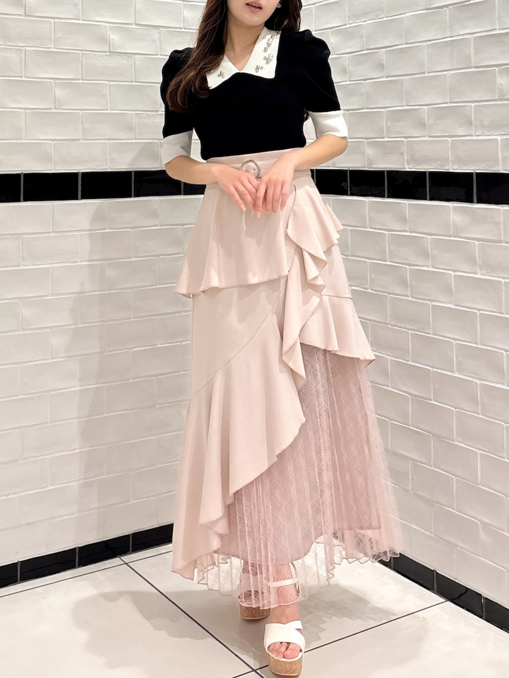 ピンク系のスカート、ホワイト系のサンダル、その他のニット/セーターを着用したレディースの夏コーディネートの2枚目の写真