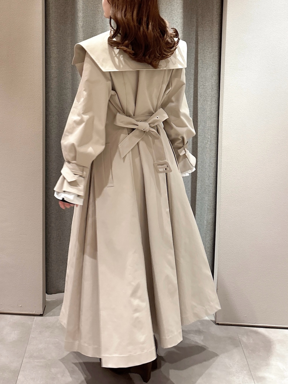 ブラック系のTシャツ/カットソー、ベージュ系のトレンチコート、グレー系のスカートを着用したレディースの春コーディネートの7枚目の写真