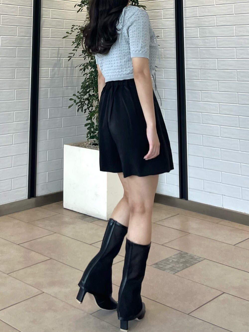 グレー系のニット/セーター、ブラック系のその他パンツ、ブラック系のブーツを着用したレディースの夏コーディネートの5枚目の写真