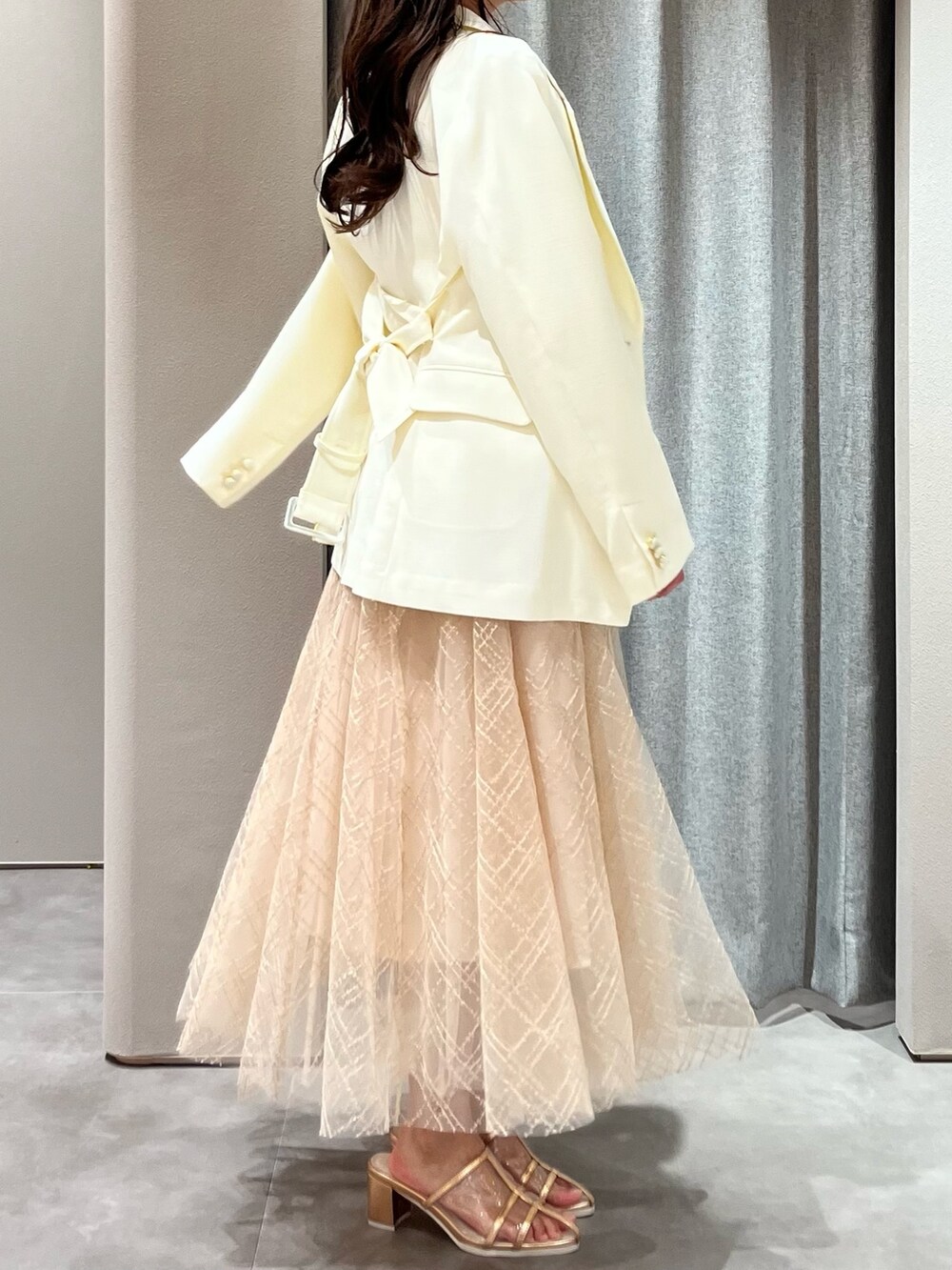 ホワイト系のニット/セーター、ホワイト系のテーラードジャケット、ベージュ系のスカートを着用したレディースの春コーディネートの8枚目の写真