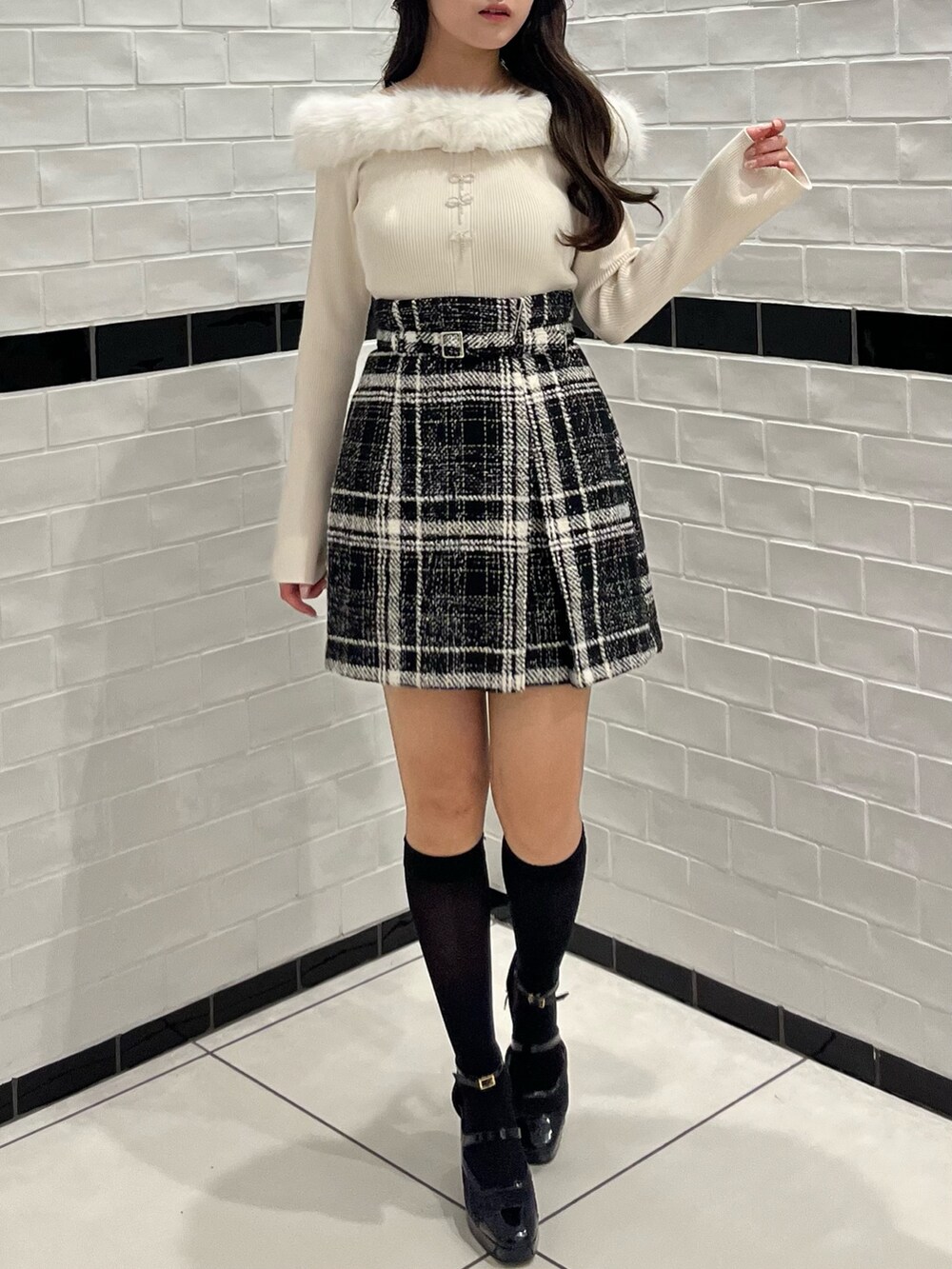 ベージュ系のニット/セーター、ブラック系のスカート、ブラック系のパンプスを着用したレディースの冬コーディネートの2枚目の写真