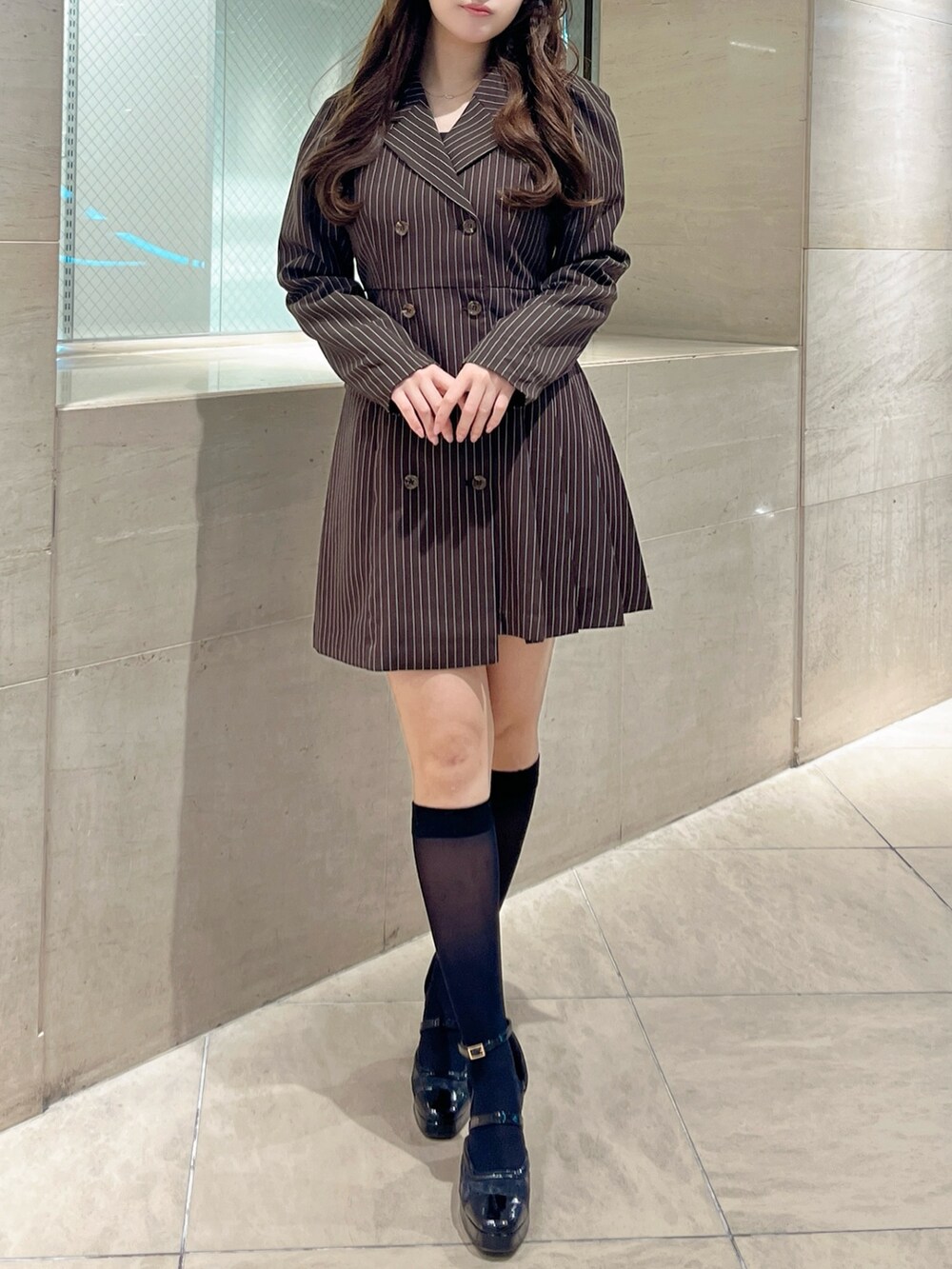 ブラック系のパンプス、ブラウン系のワンピースを着用したレディースの秋コーディネートの3枚目の写真