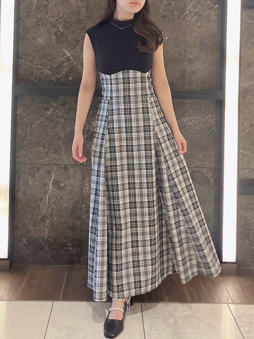 グレー系のニット/セーター、ブラック系のワンピース、ブラック系のパンプスを着用したレディースの夏コーディネートの5枚目の写真