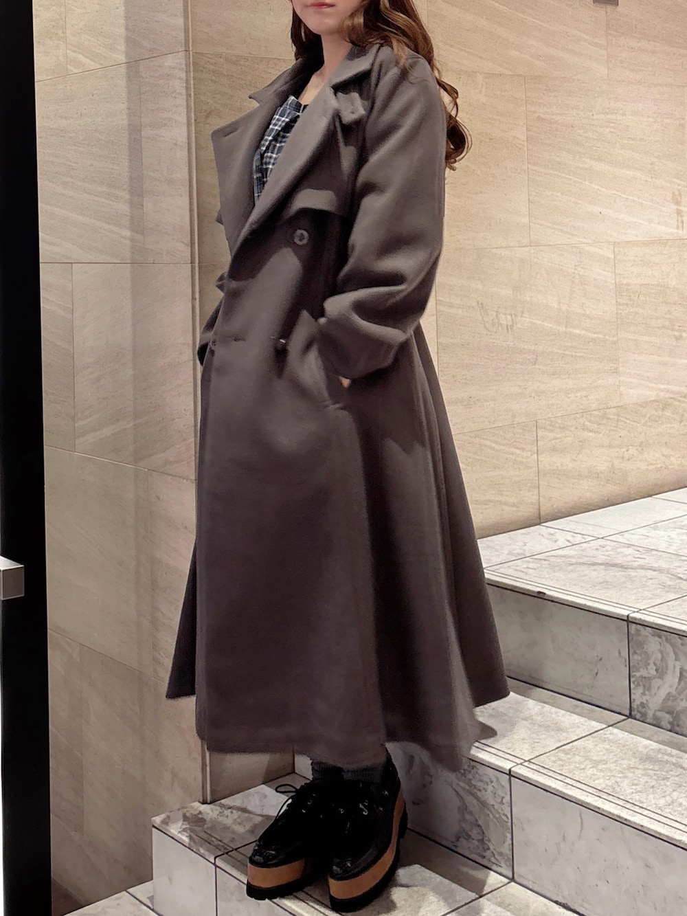 ブラウン系のトレンチコート、ブルー系のワンピース、その他のローファーを着用したレディースの秋コーディネートの6枚目の写真