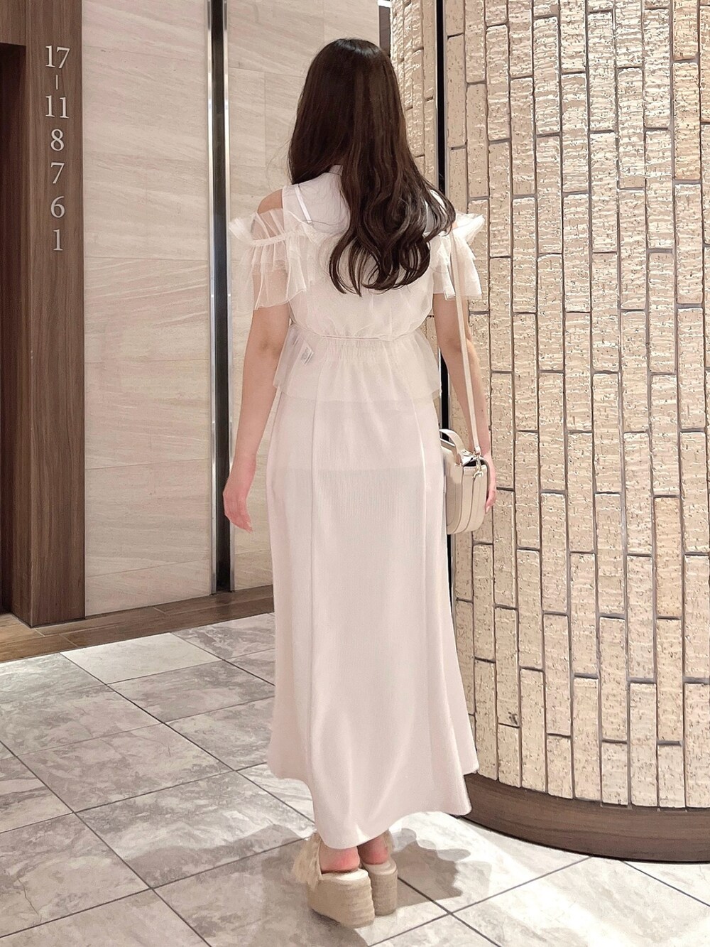 ホワイト系のワンピース、ホワイト系のハンドバッグ、オレンジ系のサンダルを着用したレディースの夏コーディネートの5枚目の写真