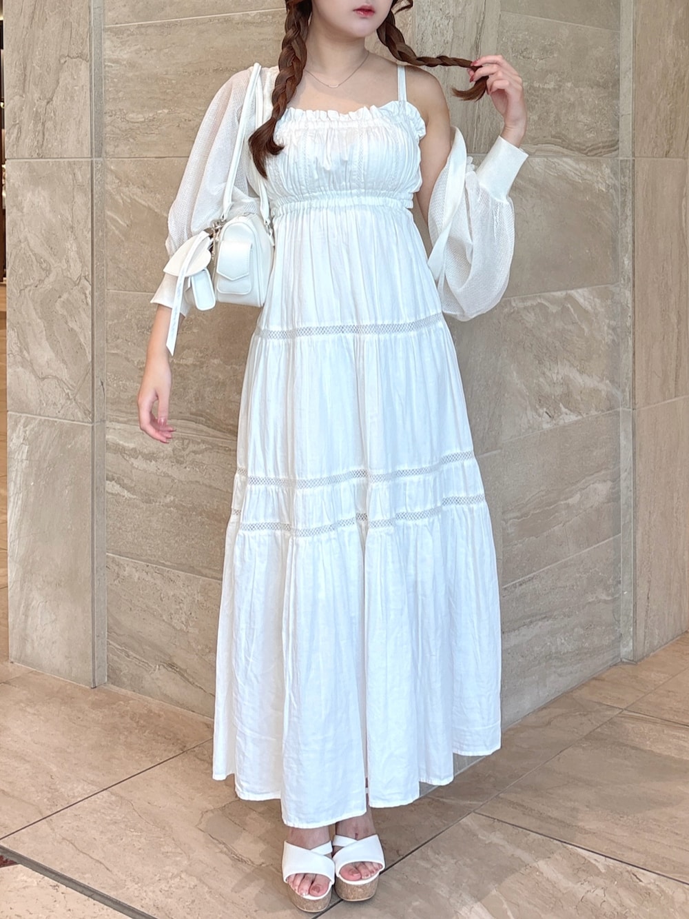 ホワイト系のワンピース、ホワイト系のカーディガン/ボレロ、ホワイト系のボストンバッグを着用したレディースの夏コーディネートの3枚目の写真