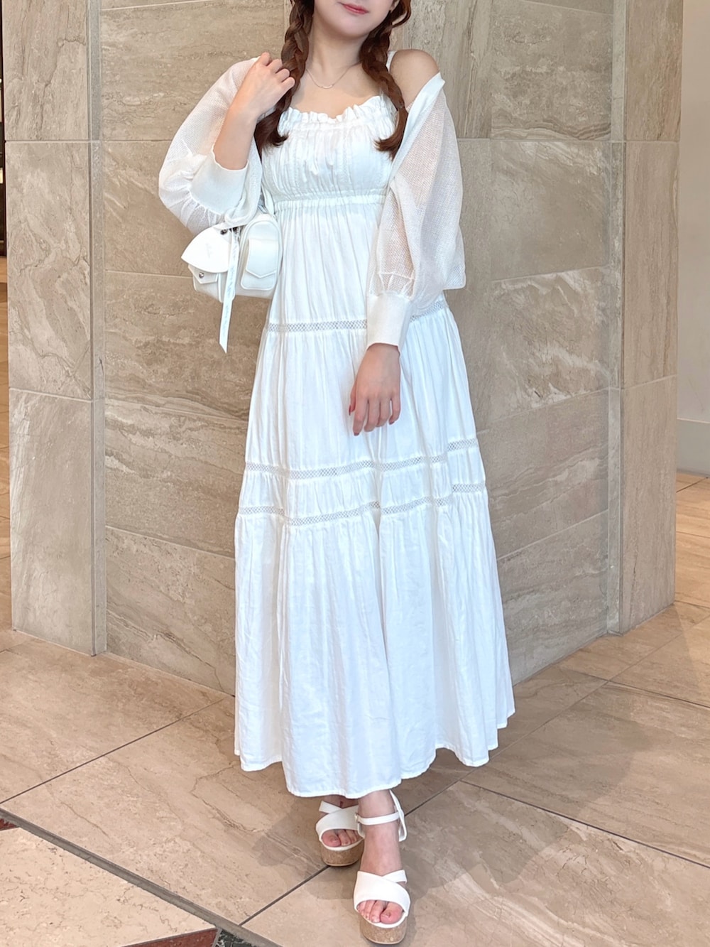 ホワイト系のワンピース、ホワイト系のカーディガン/ボレロ、ホワイト系のボストンバッグを着用したレディースの夏コーディネートの2枚目の写真