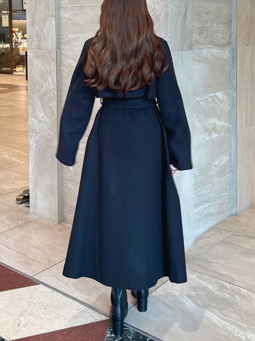 ブラック系のニット/セーター、ブラック系のスカート、ブラウン系のショルダーバッグを着用したレディースの秋コーディネートの5枚目の写真