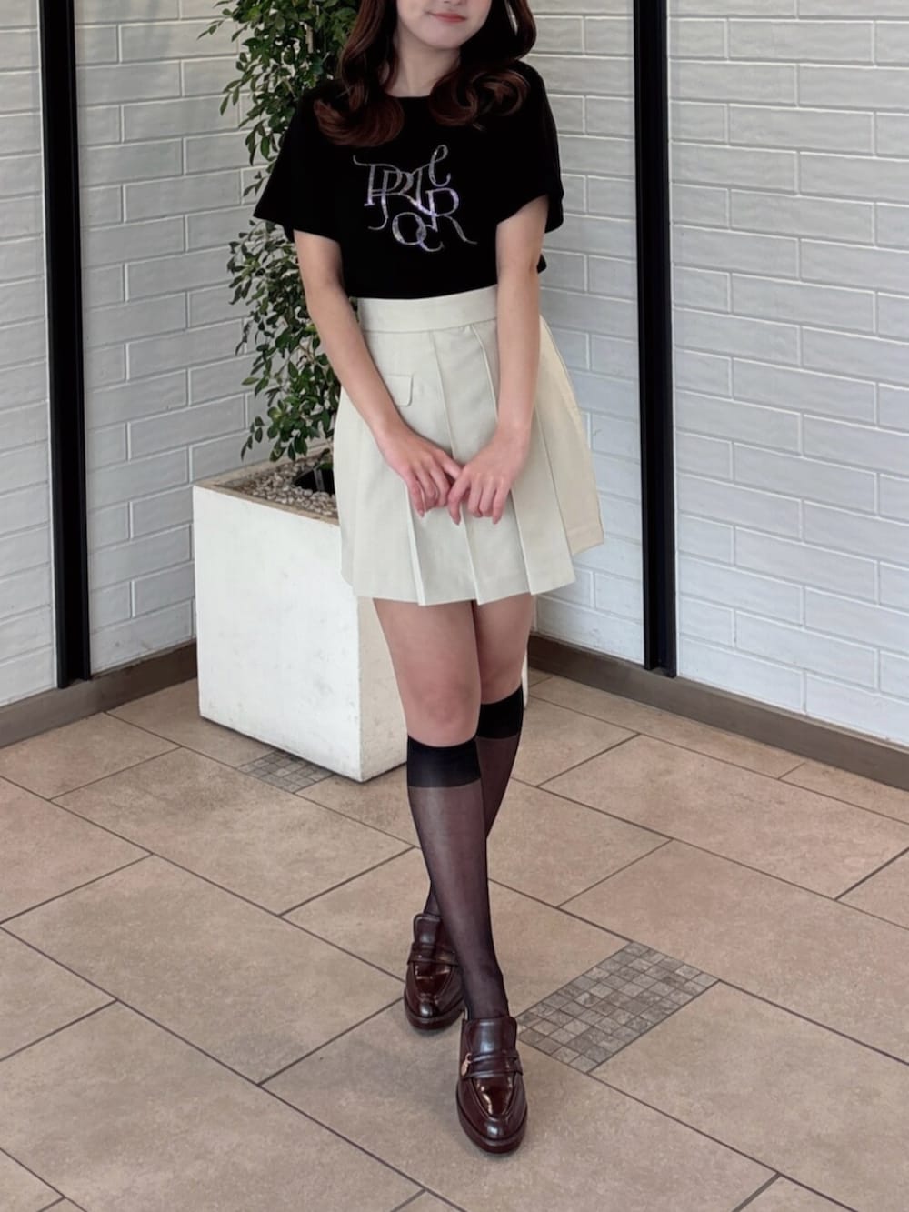 ブラウン系のパンプス、ブラック系のTシャツ/カットソー、ベージュ系のスカートを着用したレディースの夏コーディネートの6枚目の写真
