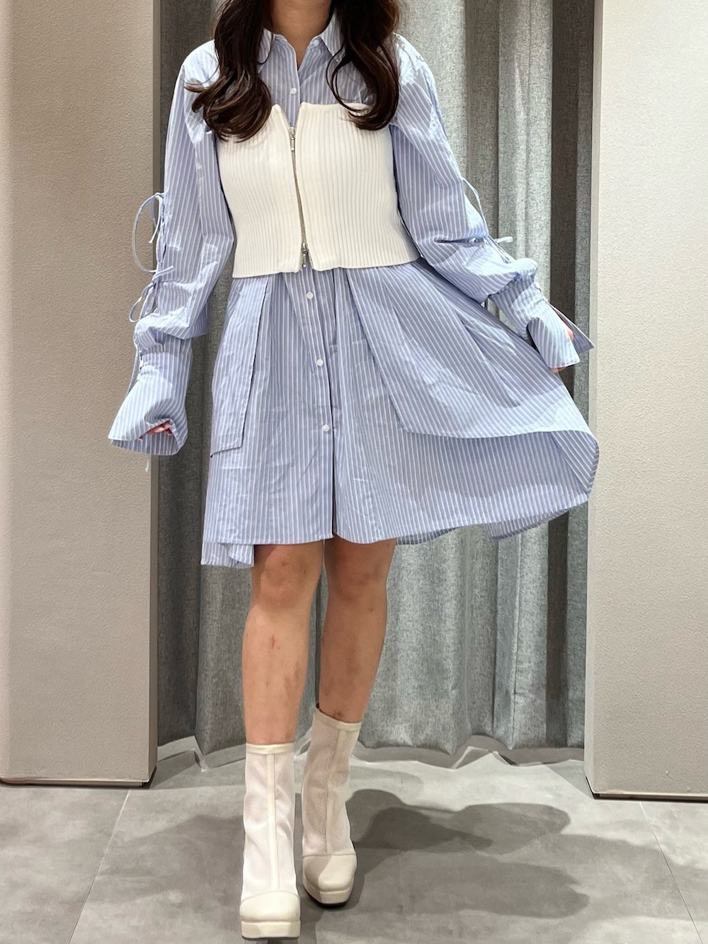 ホワイト系のキャミソール、ブルー系のシャツワンピース、ホワイト系のブーツを着用したレディースの冬コーディネートの2枚目の写真