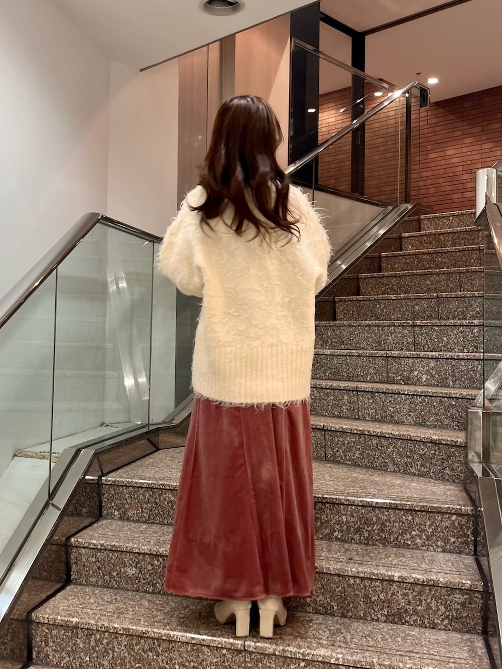 ホワイト系のカーディガン/ボレロ、グレー系のニット/セーター、ピンク系のワンピースを着用したレディースの冬コーディネートの3枚目の写真