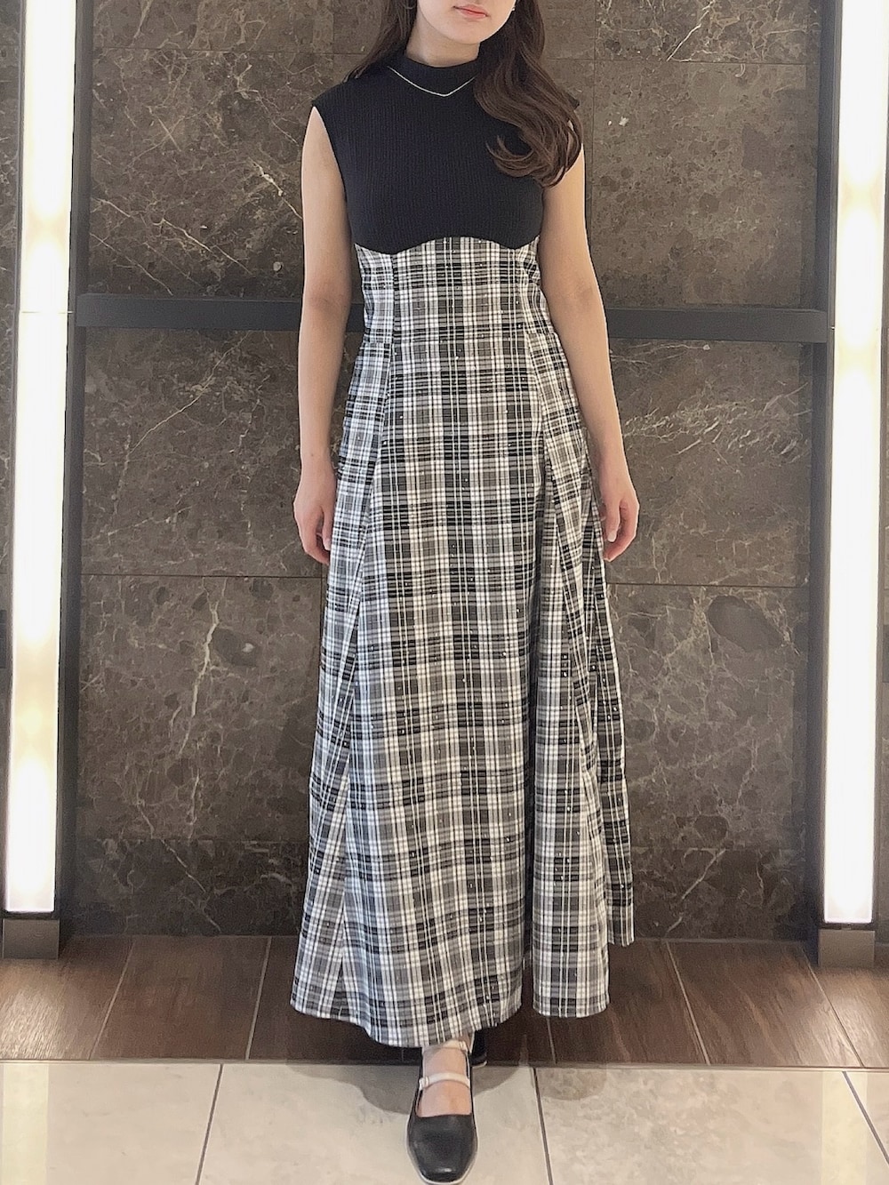 グレー系のニット/セーター、ブラック系のワンピース、ブラック系のパンプスを着用したレディースの夏コーディネートの7枚目の写真