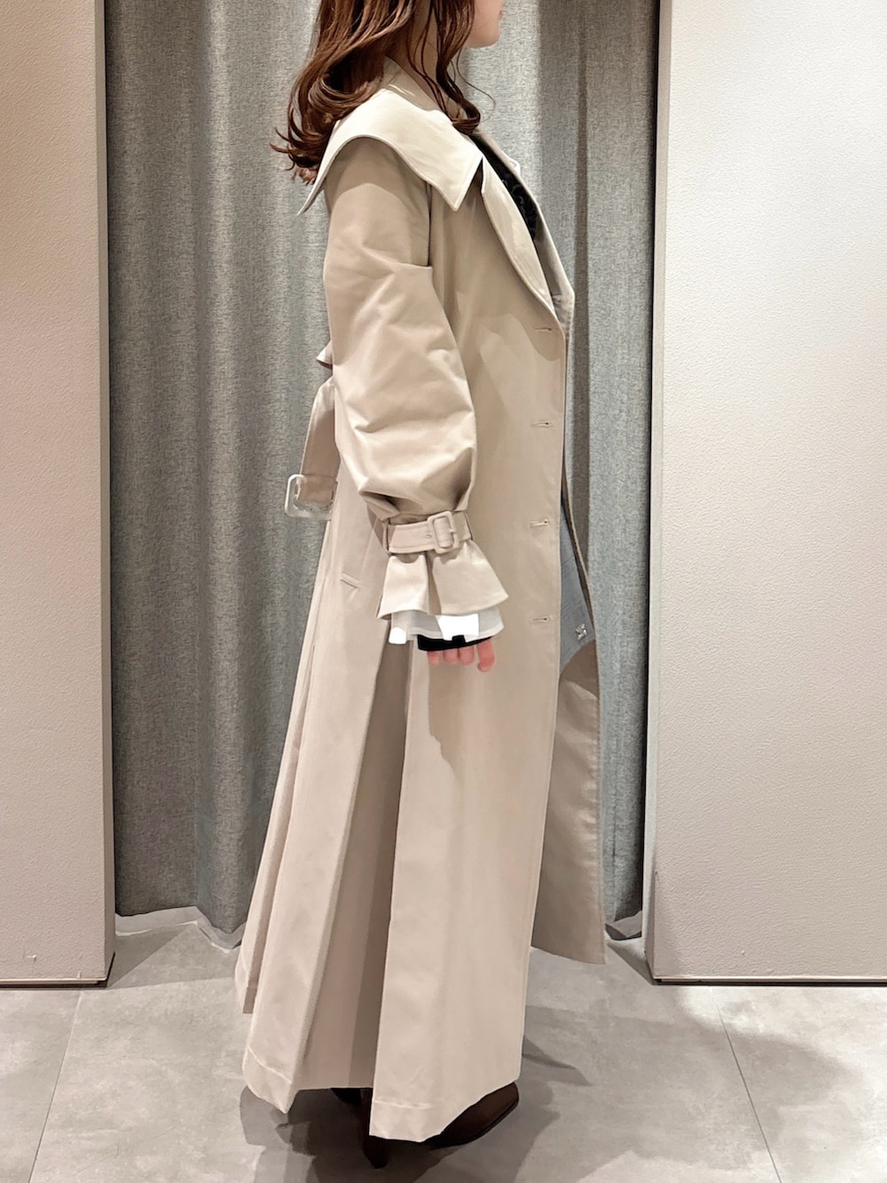 ブラック系のTシャツ/カットソー、ベージュ系のトレンチコート、グレー系のスカートを着用したレディースの春コーディネートの5枚目の写真