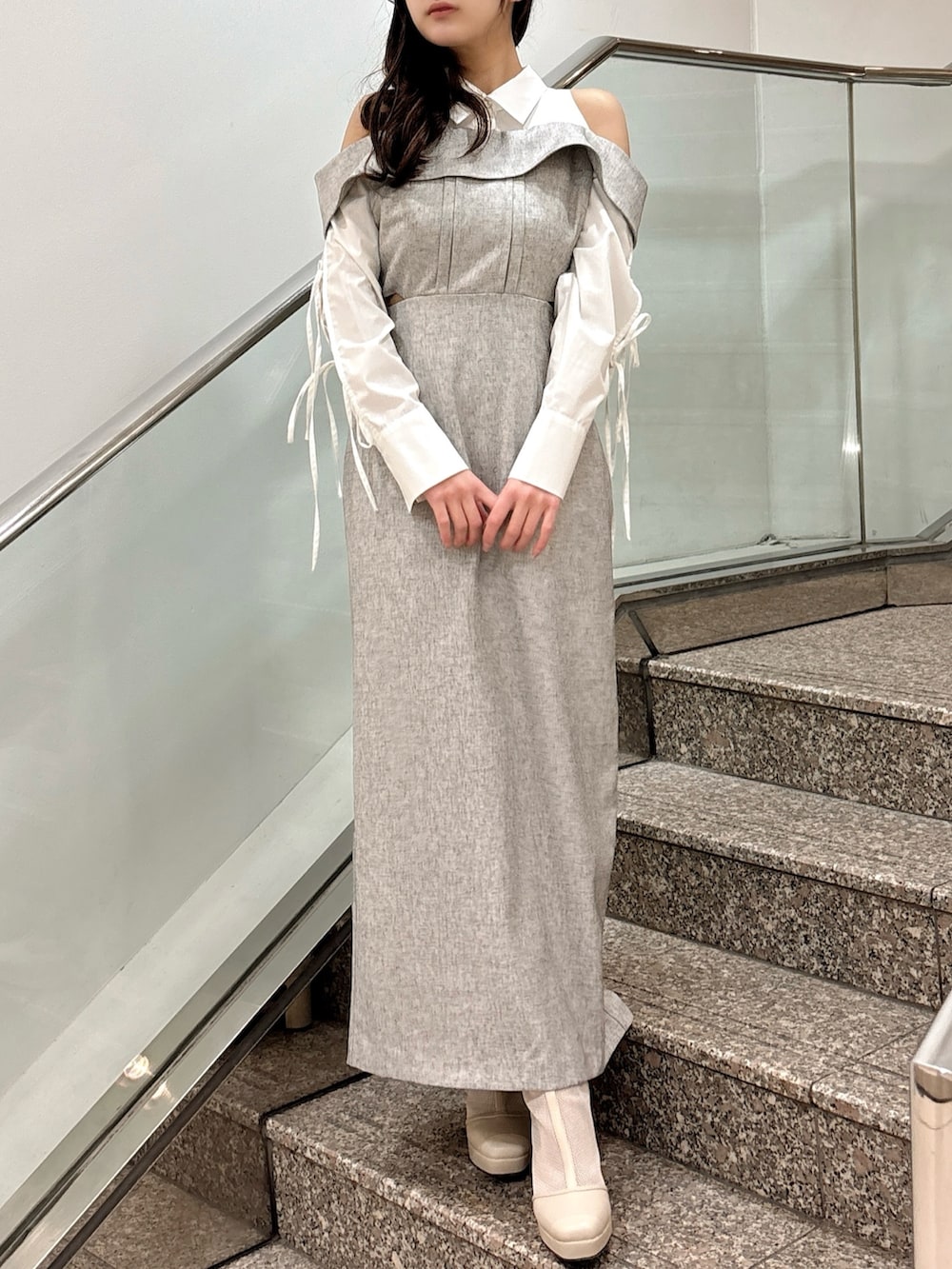 グレー系のワンピース、ベージュ系のブーツを着用したレディースの春コーディネートの2枚目の写真