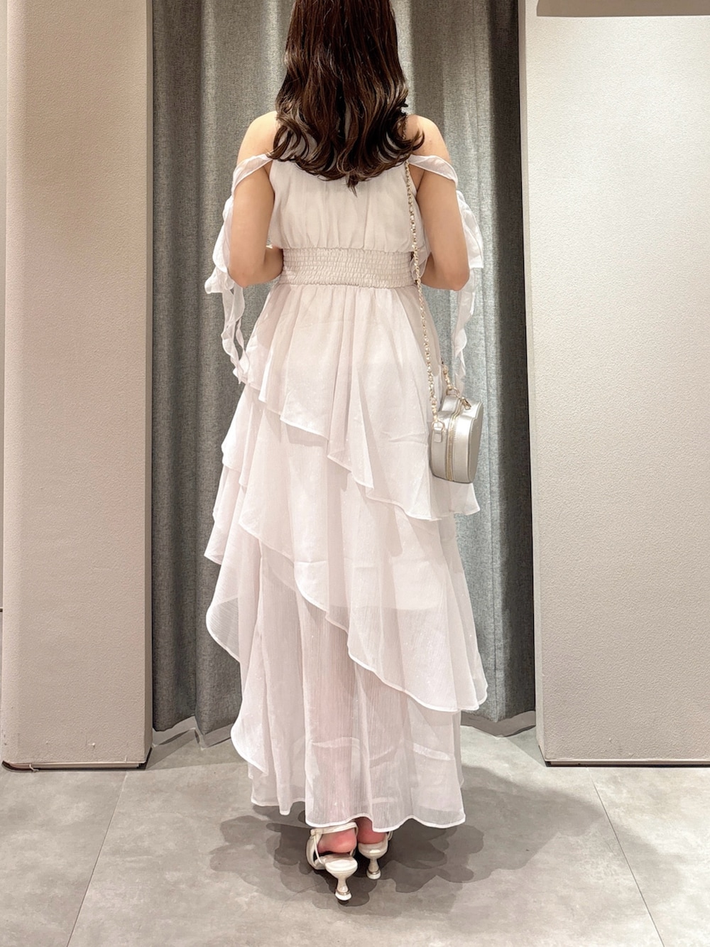 ピンク系のワンピース、シルバー系のショルダーバッグ、ホワイト系のパンプスを着用したレディースの夏コーディネートの8枚目の写真