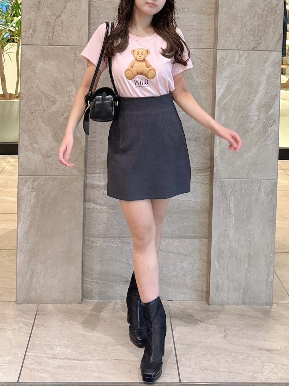 ピンク系のTシャツ/カットソー、グレー系のスカート、ブラック系のブーツを着用したレディースの夏コーディネートの3枚目の写真