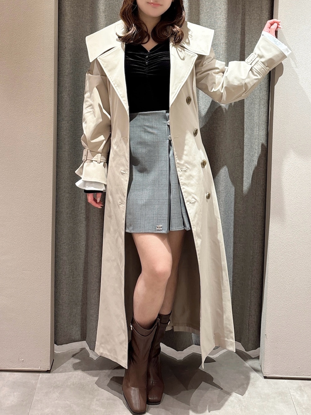 ブラック系のTシャツ/カットソー、ベージュ系のトレンチコート、グレー系のスカートを着用したレディースの春コーディネートの4枚目の写真