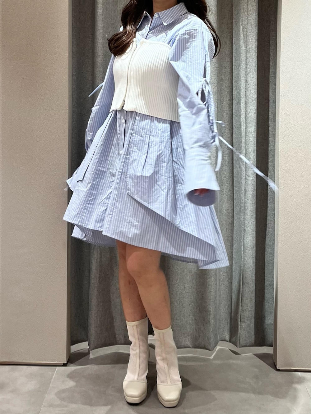 ホワイト系のキャミソール、ブルー系のシャツワンピース、ホワイト系のブーツを着用したレディースの冬コーディネートの4枚目の写真