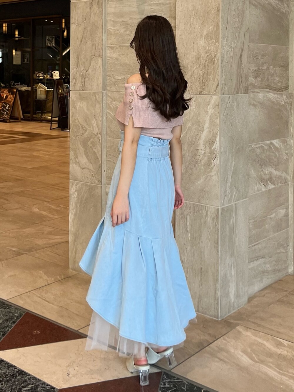 ピンク系のニット/セーター、ブルー系のスカート、ホワイト系のパンプスを着用したレディースの夏コーディネートの8枚目の写真