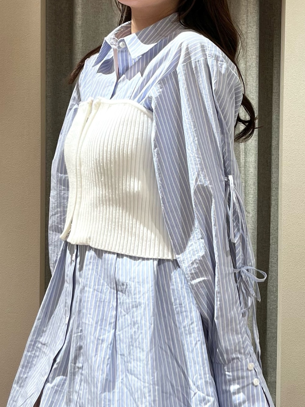 ホワイト系のキャミソール、ブルー系のシャツワンピース、ホワイト系のブーツを着用したレディースの冬コーディネートの10枚目の写真