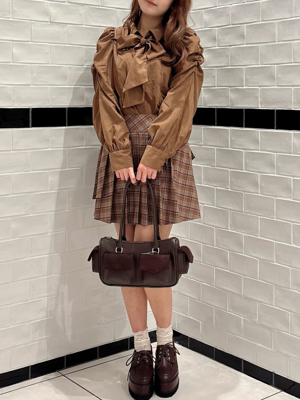 ブラウン系のシャツ/ブラウス、ブラウン系のボストンバッグ、ブラウン系のスカートを着用したレディースの秋コーディネートの4枚目の写真