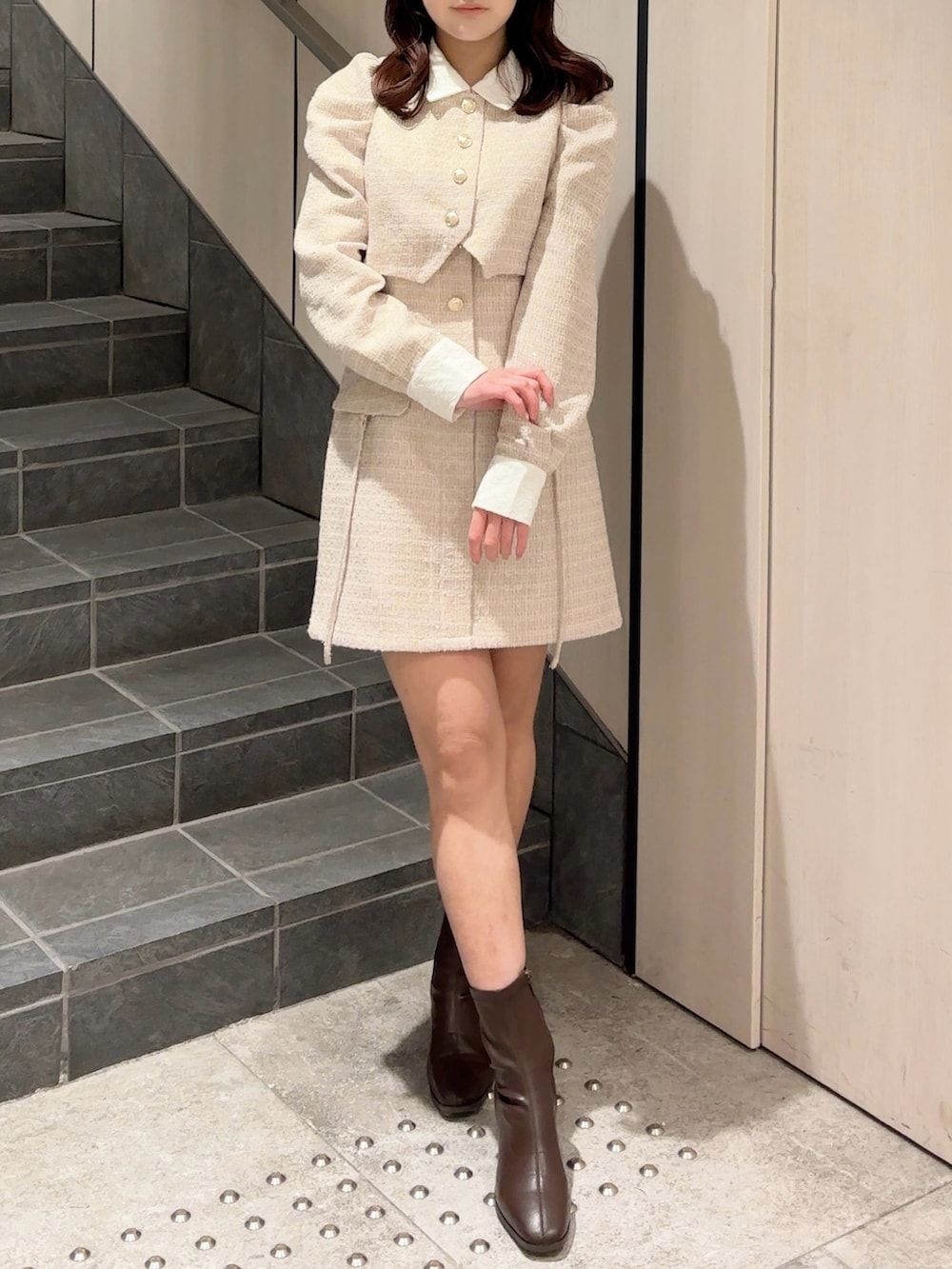 ベージュ系のワンピース、ブラウン系のブーツを着用したレディースの冬コーディネートの2枚目の写真