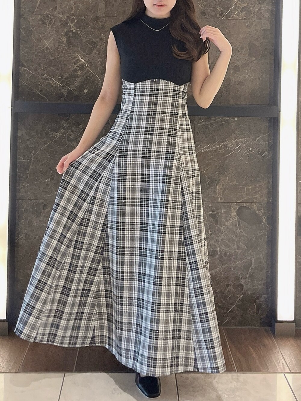 グレー系のニット/セーター、ブラック系のワンピース、ブラック系のパンプスを着用したレディースの夏コーディネートの6枚目の写真