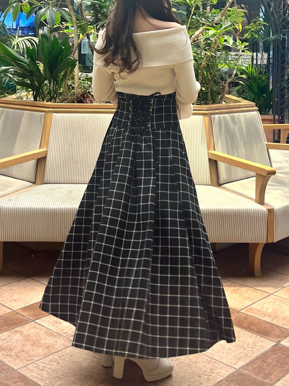 ホワイト系のニット/セーター、ブラック系のスカート、ホワイト系のブーツを着用したレディースの春コーディネートの7枚目の写真