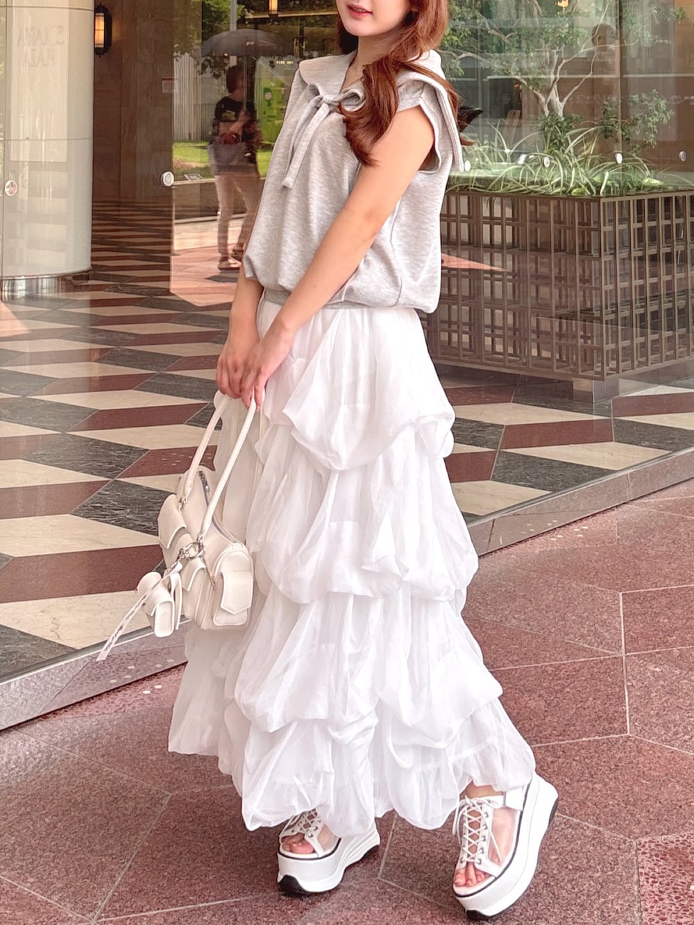 グレー系のTシャツ/カットソー、ホワイト系のスカート、ホワイト系のボストンバッグを着用したレディースの夏コーディネートの5枚目の写真