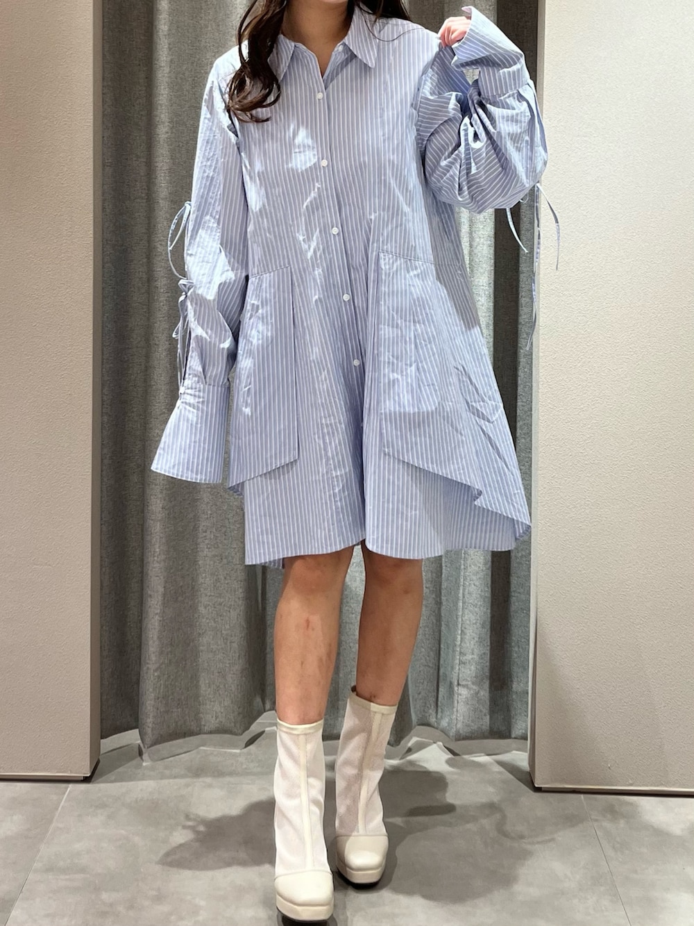 ブルー系のシャツワンピース、ホワイト系のブーツを着用したレディースの冬コーディネートの3枚目の写真