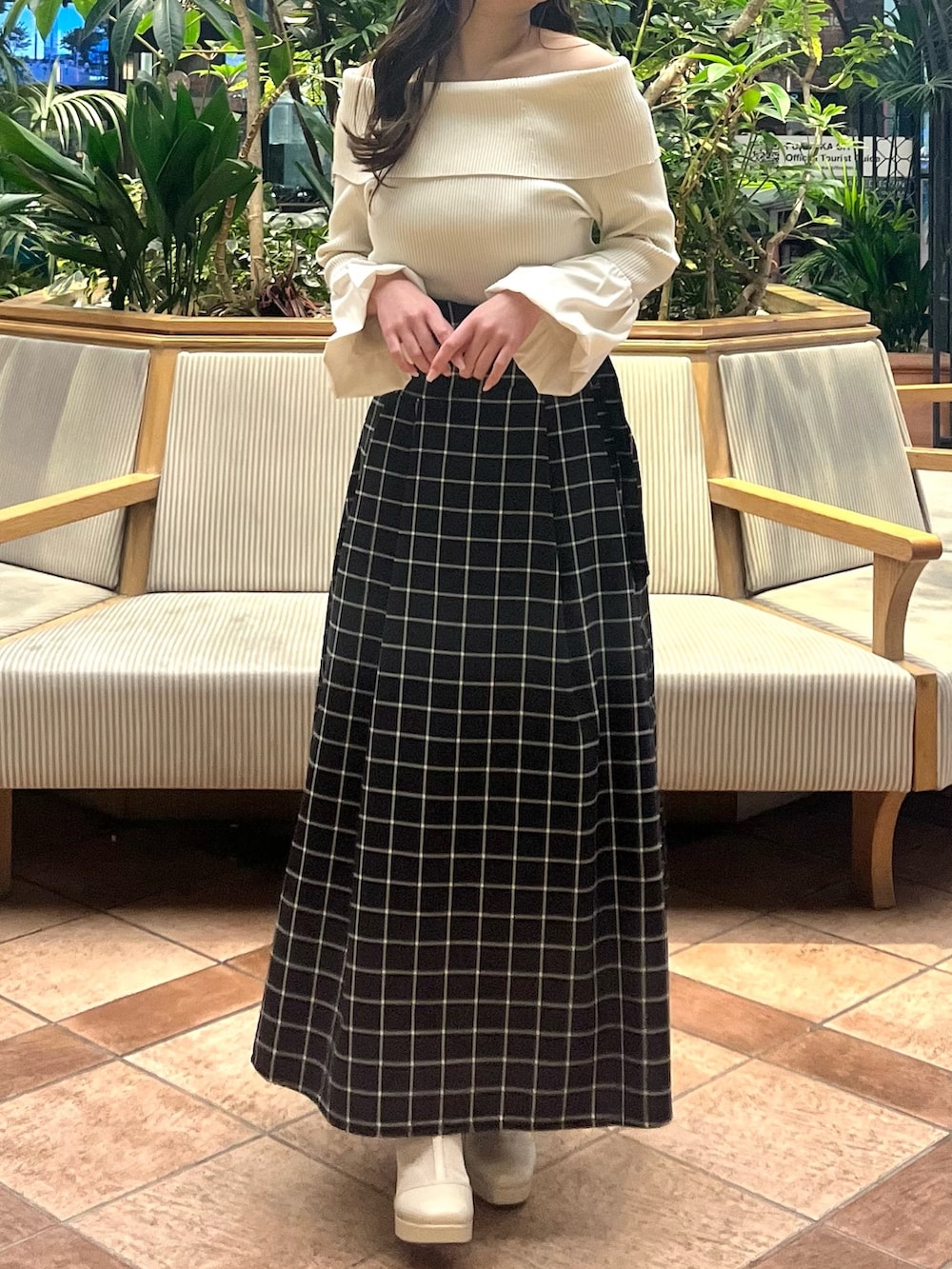 ホワイト系のニット/セーター、ブラック系のスカート、ホワイト系のブーツを着用したレディースの春コーディネートの5枚目の写真