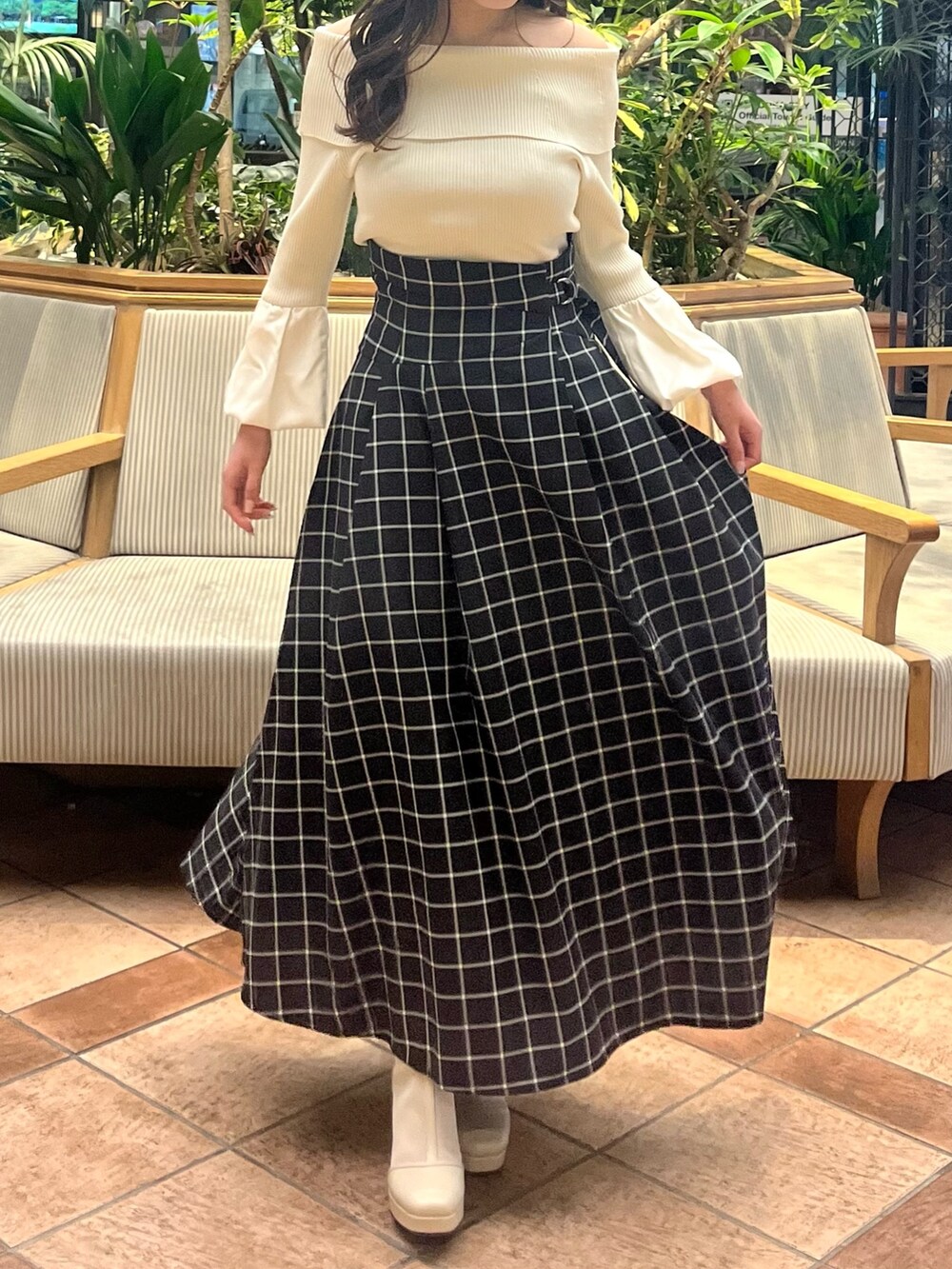 ホワイト系のニット/セーター、ブラック系のスカート、ホワイト系のブーツを着用したレディースの春コーディネートの3枚目の写真