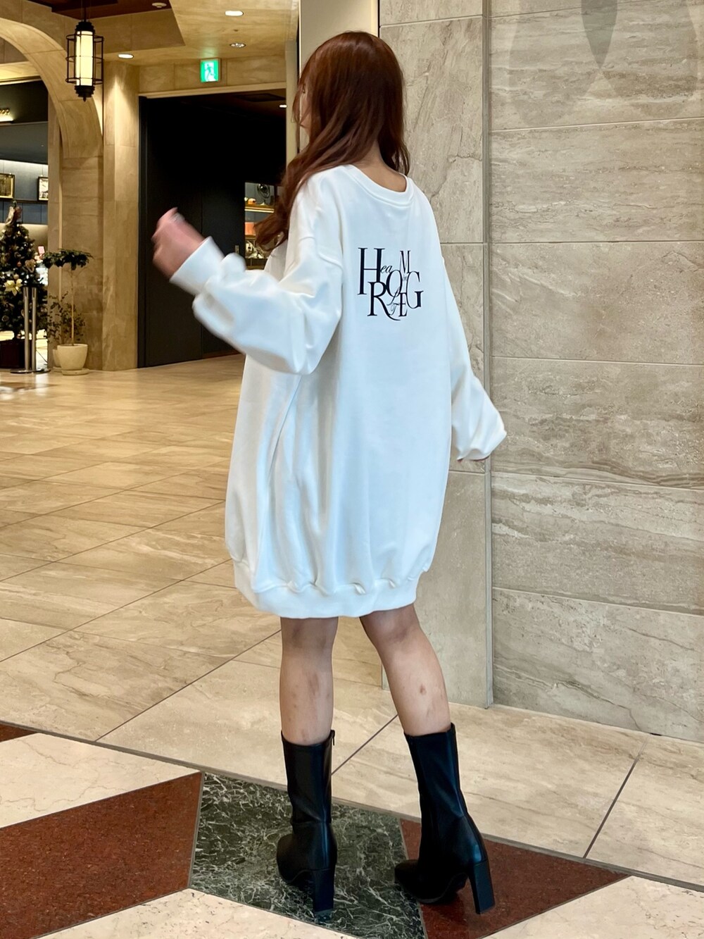 ホワイト系のTシャツ/カットソー、グレー系のスカート、ブラック系のブーツを着用したレディースの冬コーディネートの2枚目の写真