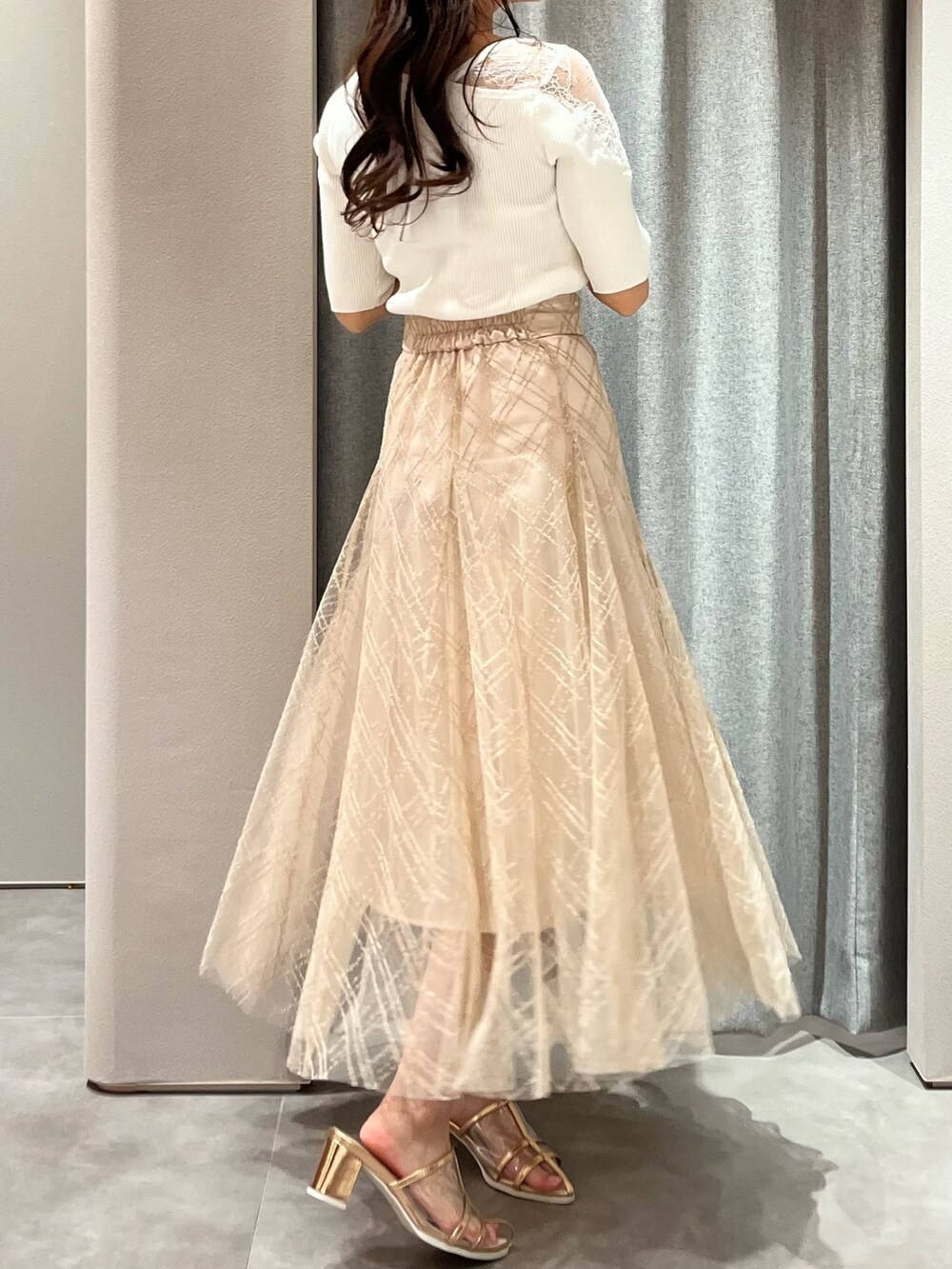 ホワイト系のニット/セーター、ベージュ系のスカート、ゴールド系のパンプスを着用したレディースの春コーディネートの8枚目の写真